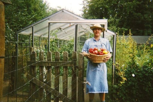 Man-poseert-met-oogst-uit-moestuin-Wijnegem-jaren-2020