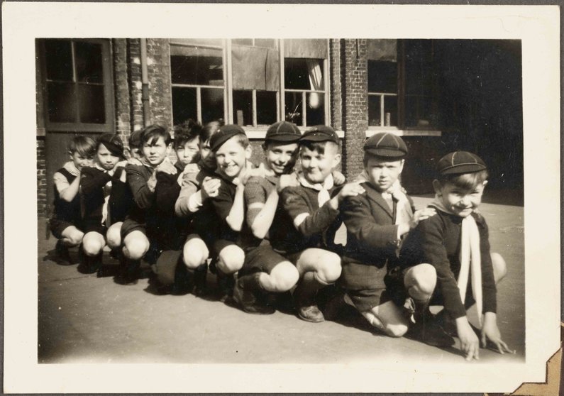 Groepsfoto-van-hurkende-scouts-op-een-rij